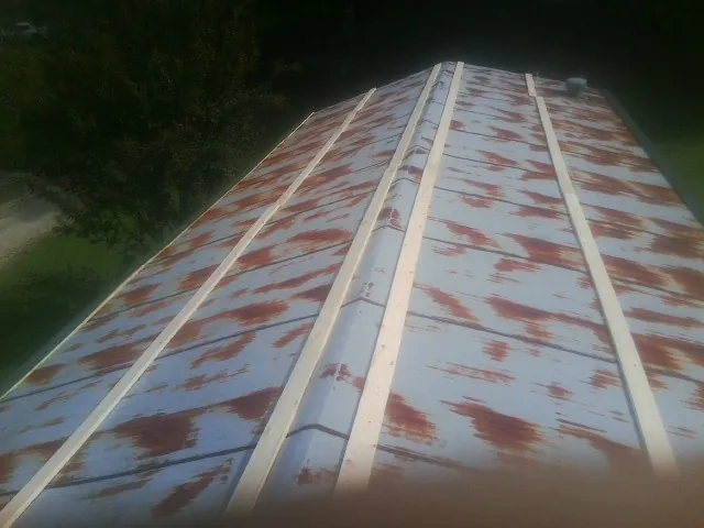 Rusted metal roof panels with new wood purlins before replacement — Storm Damage Roof Repair in Welch by Roofing Brothers