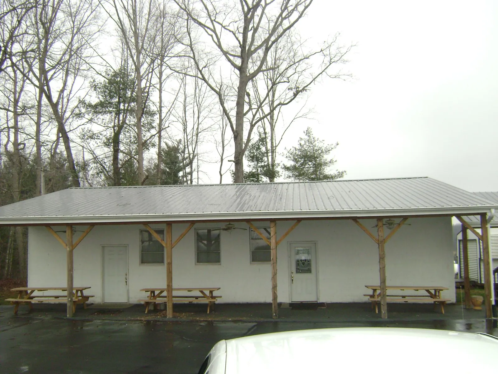 Gray metal roof over a block building with a timber post porch in Welch